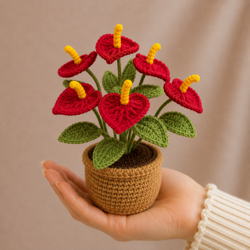 Crocheted anthurium plant in tan woven pot, red hearts with yellow tips and green leaves