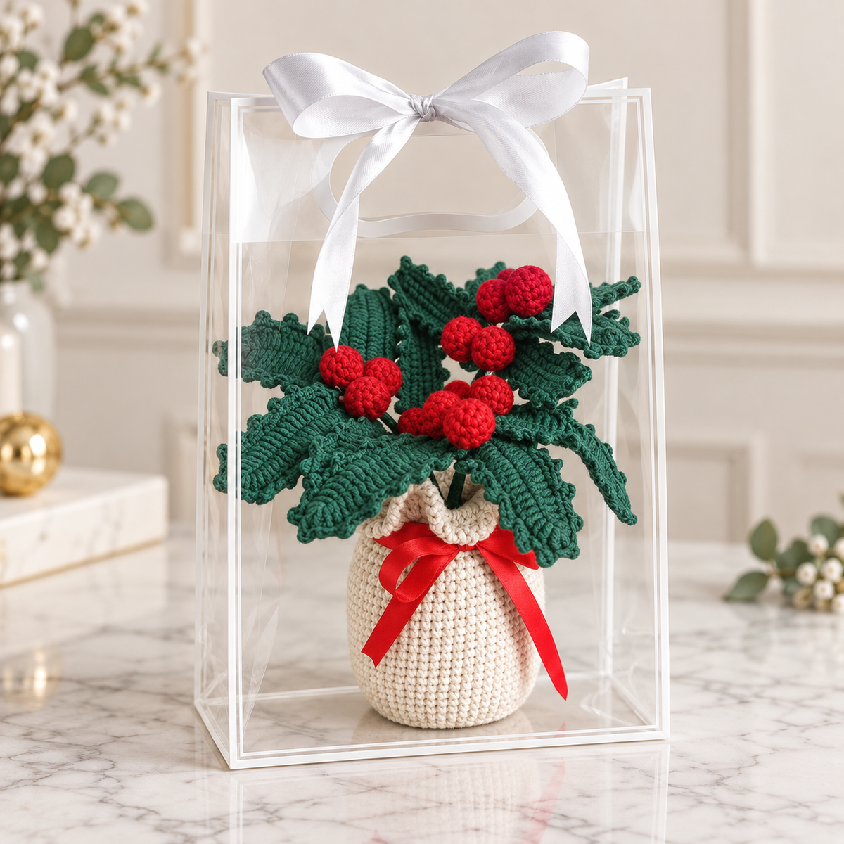 Crocheted potted holly plant decor in clear gift box, green leaves, red berries, red ribbon