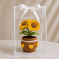 Crocheted potted sunflower plant in clear gift box with white ribbon, yellow blooms