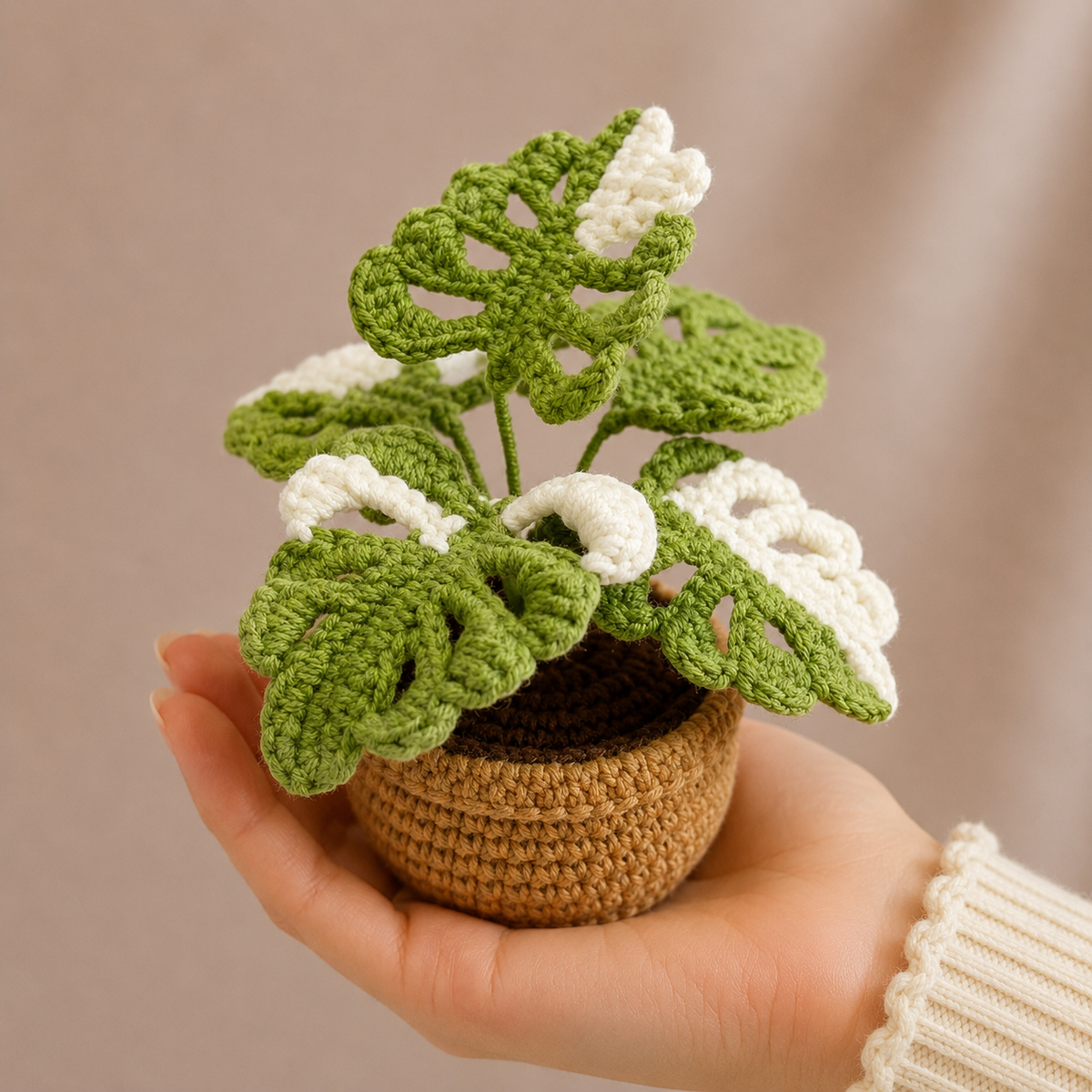 Crochet monstera plant with bright green leaves in a tan knitted pot
