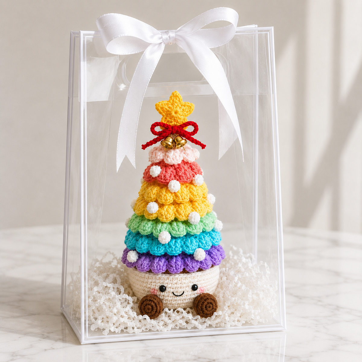 Crochet Christmas tree in clear gift box, rainbow layers with smiling cream pot base and star bow
