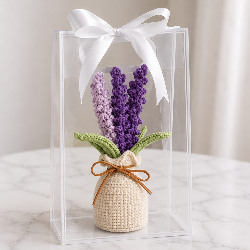 Crocheted lavender plant in cream pot, green leaves, displayed in clear gift box with white bow