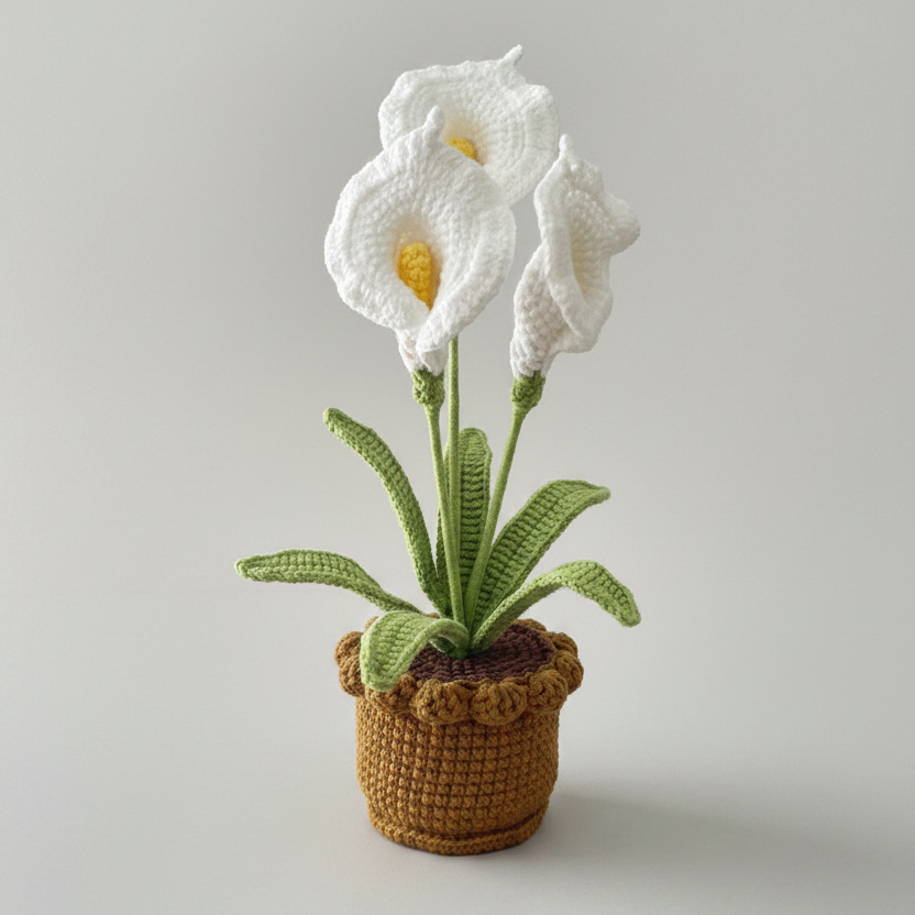Crocheted white lily plant with yellow centers, green leaves, in brown fabric pot