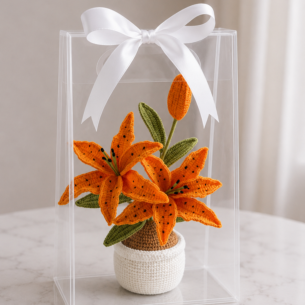 Handmade crochet orange lily in white pot inside clear gift box with white bow