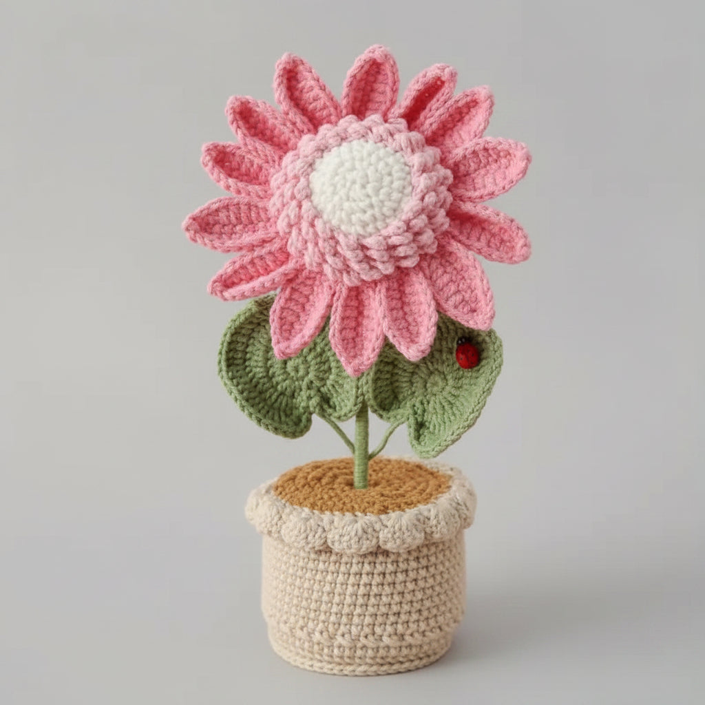 Handmade crochet sunflower in pot, pink petals, green leaves, brown stem