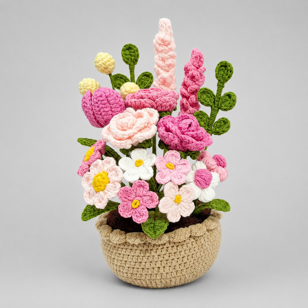Crochet flower arrangement in beige pot with pink, white, and yellow wildflower amigurumi
