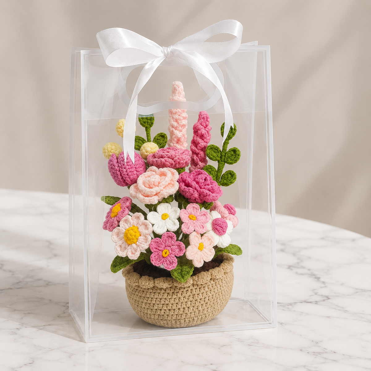 Amigurumi crochet flower arrangement in beige pot inside clear box with white ribbon