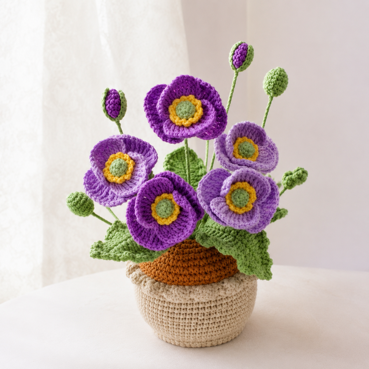 Crocheted purple poppies bouquet in beige yarn pot with green leaves
