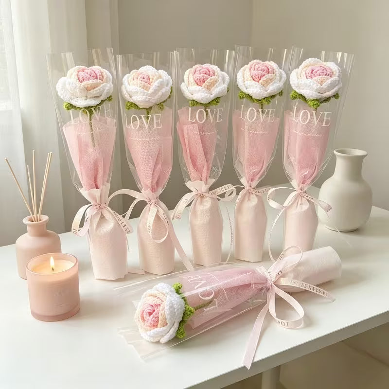 Five pink crocheted rose bouquets with sheer sleeves, LOVE labels, and ribbon bows