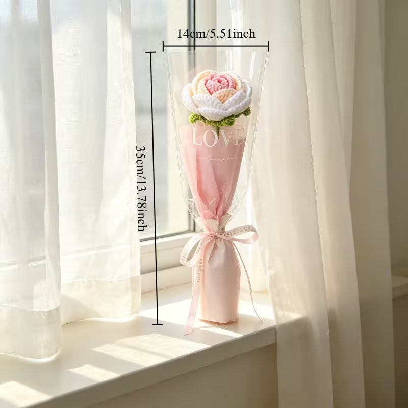 Pink crocheted rose single-stem bouquet with sheer wrap and ribbon tie